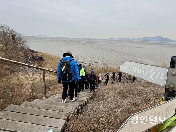 지난 11일 정기 모임에서 강화 남단 갯벌 옆으로 지나는 강화나들길 제8코스를 걷고 있는 사단법인 강화나들길 회원들. 2026.3.11 /박경호기자 pkhh@kyeongin.com