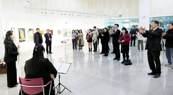 제1회 토파즈 작품전시회가 열린 대전서구문화원 1층 전시실에서 참석자들이  축하연주를 감상하고 있다. 사진 =정창영 작가