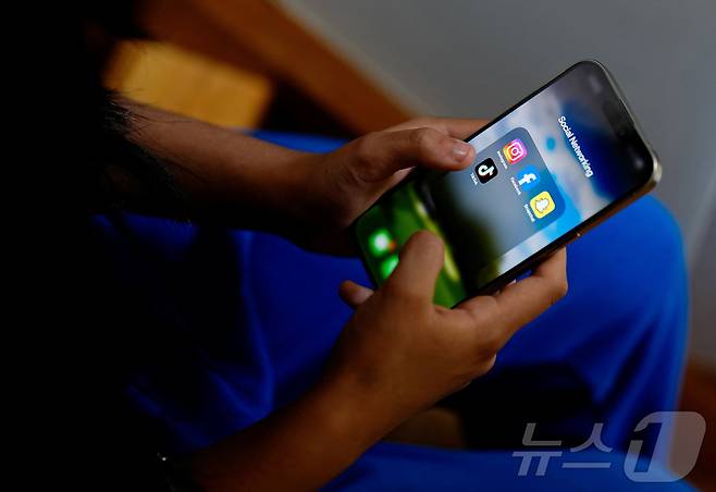 호주의 한 고등학생이 스마트폰으로 소셜 미디어 어플리케이션 화면을 보고 있다. ⓒ 로이터=뉴스1