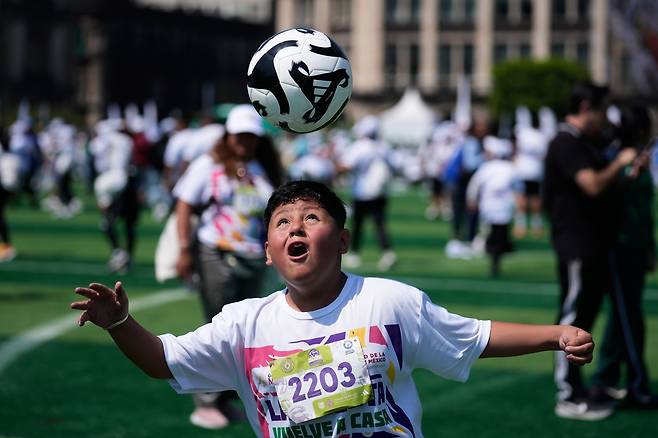 3월 15일(현지 시각) 멕시코 수도 멕시코시티의 소칼로 광장에서 열린 ‘가장 큰 축구 수업’ 기네스 세계 기록 도전 행사에서 한 어린이가 축구 머리고 공을 컨트롤하는 기술을 연습하고 있다./AP 연합뉴스