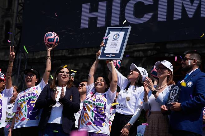 15일 멕시코 수도 멕시코시티의 클라라 브루가다 시장이 멕시코시티 소칼로 광장에서 ‘가장 큰 축구 수업’ 부문 기네스 세계 기록 인증서를 들어 보이고 있다./AP 연합뉴스