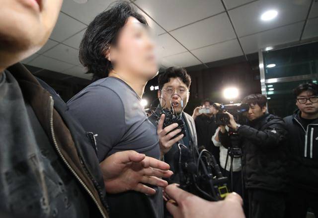 부산의 한 아파트에서 항공사 기장을 흉기로 살해한 혐의를 받는 50대 피의자가 지난 17일 오후 부산진경찰서로 압송되고 있다. 부산=뉴스1