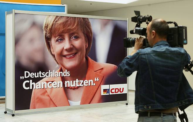 2005년 8월 4일 독일 베를린의 한 텔레비전 카메라맨이 메르켈 전 총리가 속한 기독민주연합(CDU)의 선거운동 법안을 촬영하고 있다. 게티이미지