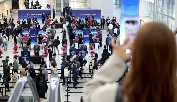 18일 경기도 수원시 영통구 수원컨벤션센터에서 열린 제57기 삼성전자 정기주주총회에서 주주들이 주주 확인을 하고 있다. 공동취재