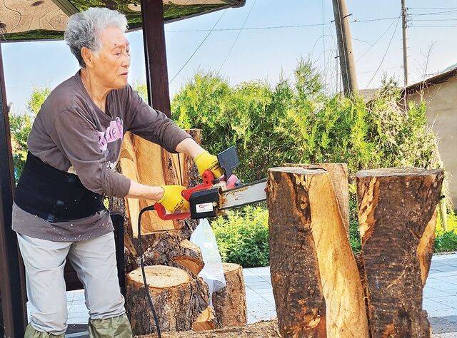 전기톱을 들고 작업하는 작가. 작가 제공