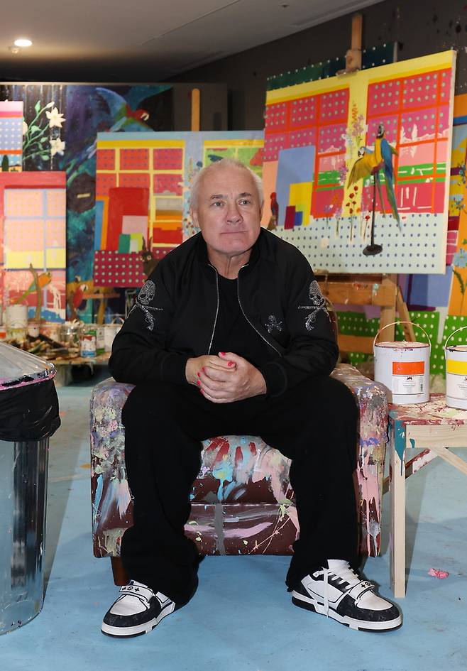 영국 작가 데이미언 허스트가 18일 서울 종로구 국립현대미술관에서 열린 ‘진실은 없어 그러나 모든 것은 가능하지’ 개인전에 전시된 작가의 스튜디오에서 포즈를 취하고 있다. <연합뉴스>