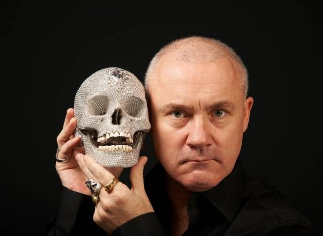 영국의 현대미술가 데이미언 허스트가 자신의 작품 ‘신의 사랑을 위하여’와 사진 촬영을 하고 있다. 다이아몬드로 장식한 이 해골 조각은 1억 달러(약 940억 원)에 판매돼 세계를 놀라게 했다.  ⓒ Damien Hirst and Science Ltd.·국립현대미술관 제공