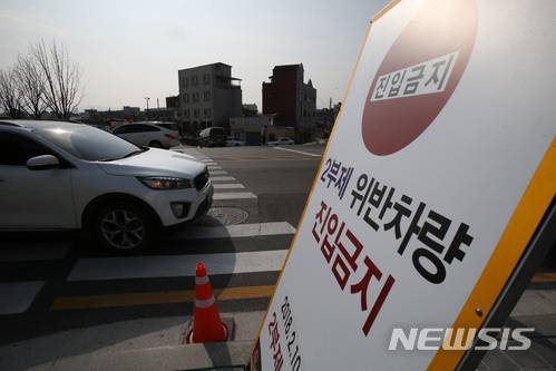 [강릉=뉴시스]김경목 기자 = 교통통제요원이 지난 2018년 2월25일 강원 강릉시 교2동 지역에서 2부제 위반차량을 단속하고 있는 모습. 2018.02.26.  photo31@newsis.com