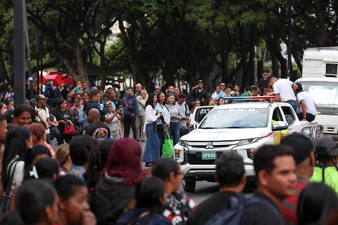 16일(현지 시간) 베네수엘라 카라카스에서 교통대란에 빠진 시민들이 경찰차를 이용해 이동하고 있다.   로이터 연합뉴스
