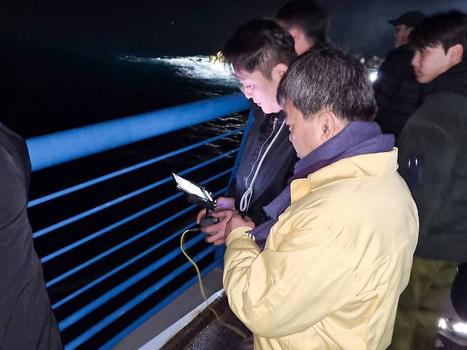 19일 밤, 남한권 울릉군수(오른쪽)가 실종자 수색이 진행 중인 울릉 천부 해중전망대 인근에서 수중 드론이 전송하는 바닷속 탐색 화면을 실시간으로 확인하고 있다. /황진영 기자