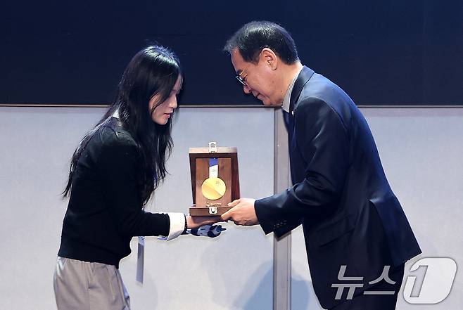 최홍훈 대한스키스노보드협회장이 19일 서울 송파구 시그니엘 서울에서 열린 스키·스노보드 국가대표 격려행사에서 최가온에게 포상금 및 선물을 전달하고 있다. 2026.3.19 ⓒ 뉴스1 박지혜 기자