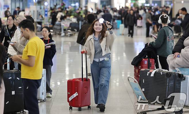 19일 인천국제공항에서 BTS 팬클럽 ‘아미’인 중국인 클로이(20)가 입국하며 아미밤(방탄소년단 공식 응원봉)을 들어 보이고 있다. 오는 21일 서울 광화문광장에서 열리는 BTS 컴백 공연을 관람하기 위해 전 세계 ‘아미’(BTS 팬)들이 속속 한국을 찾고 있다. 2026.3.19 ⓒ 뉴스1 박지혜 기자