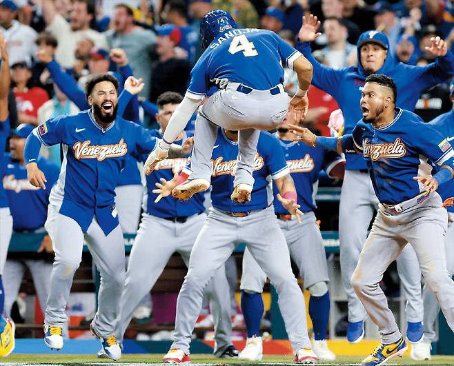 9회초 결승 득점의 순간  베네수엘라의 하비에르 사노하(가운데 등번호 4번)가 18일 미국 마이애미 론디포파크에서 열린 2026 WBC(월드베이스볼클래식) 미국과의 결승전에서 9회초 결승 득점을 올린 후 펄쩍 뛰어오르며 팀 동료들과 함께 기뻐하고 있다. 베네수엘라가 미국을 3대2로 꺾고 WBC 첫 우승의 감격을 누렸다./Imagn Images 연합뉴스