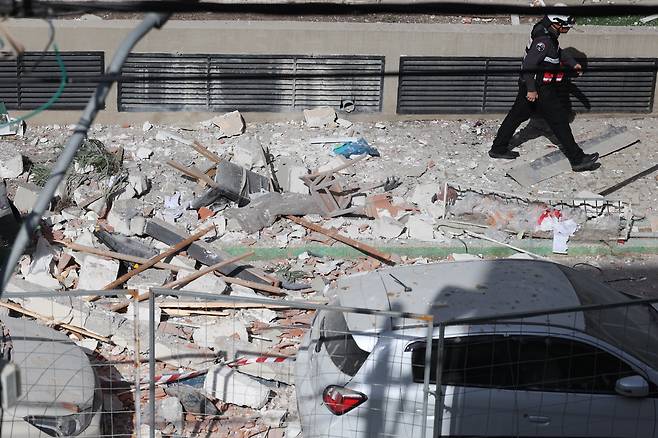 18일 소방대원이 이란의 집속탄 분산형 탄도 미사일이 아파트를 타격해 이스라엘인 부부가 사망한 현장의 피해 상황을 조사하고 있다. /EPA 연합뉴스