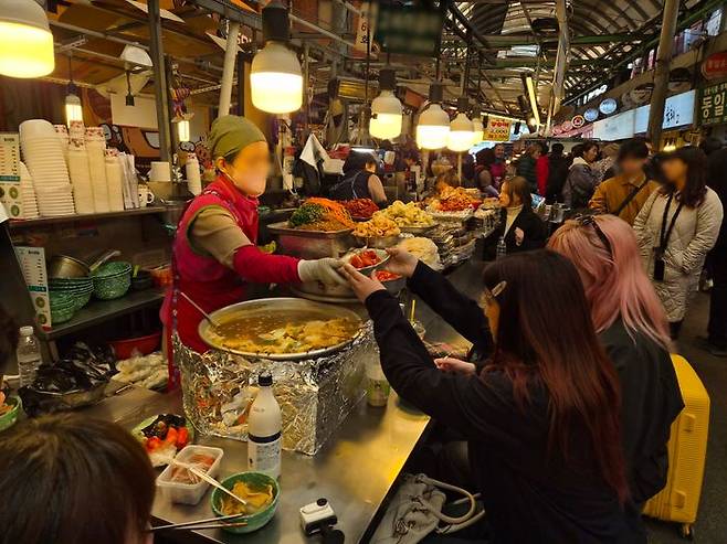 한 외국인 관광객이 주문한 떡볶이를 받고 있다.ⓒ데일리안 허찬영 기자