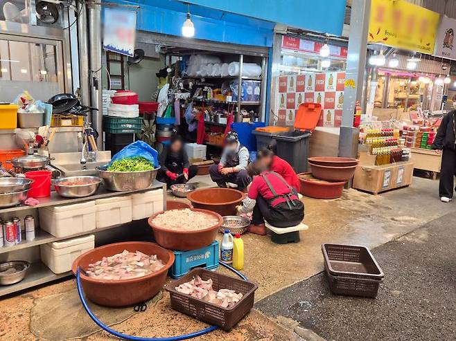 뚜껑이 열린 음식물 쓰레기통 앞에서 식재료 손질을 하고 있다.ⓒ데일리안 허찬영 기자