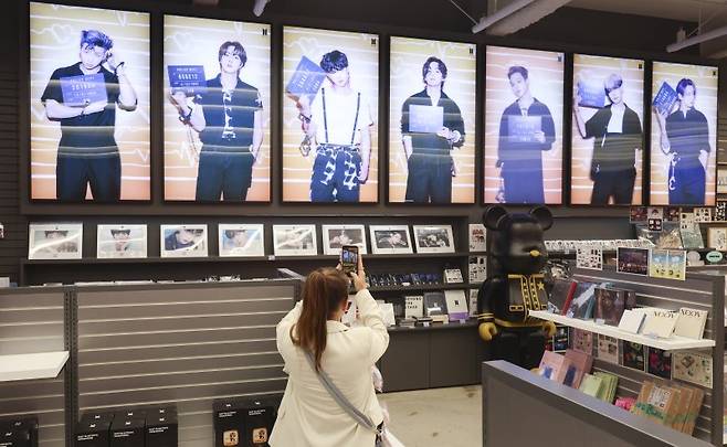 방탄소년단(BTS) 컴백 라이브: ARIRANG의 광화문 공연을 사흘 앞둔 18일 오후 서울 중구 명동거리에 위치한 케이메카 명동본점에서 한 외국인이 사진을 찍고 있다. 뉴시스