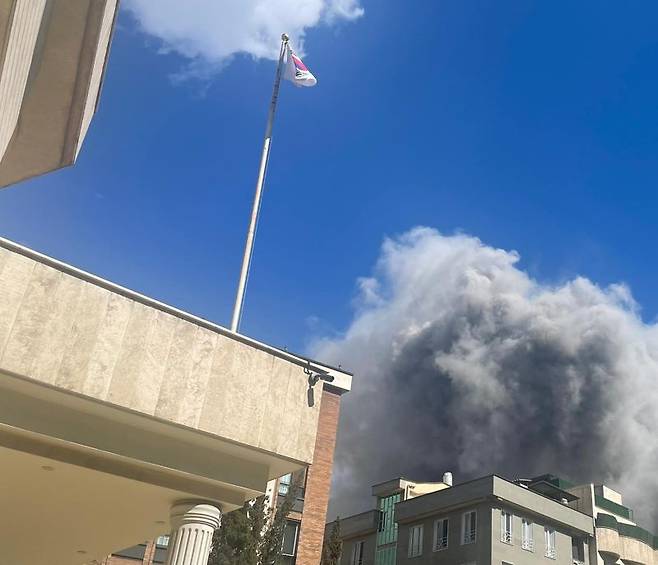 지난 1일(현지시간) 이란 테헤란 주재 한국대사관 인근에서 폭격으로 연기가 피어 오르고 있다. 한국대사관에 태극기가 걸려 있다. 외교부 제공