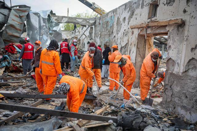 17일 카불에서 무너져 내린 재활 병원 사이로 적신월사와 자원봉사자들이 희생자를 찾고 있다. 카불=로이터 연합뉴스