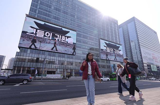 방탄소년단(BTS) 완전체 컴백 공연을 나흘 앞둔 17일 오전 서울 광화문광장에서 외국인 관광객들이 기념 촬영을 하고 있다. [사진 뉴스1]