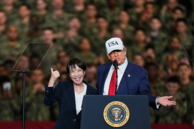 Japanese Prime Minister Sanae Takaichi (left) flashes a thumbs-up as US President Donald Trump delivers a speech during a visit to the aircraft carrier USS George Washington at the US Navy's base in Yokosuka, Japan, Oct. 28, 2025. (AP)