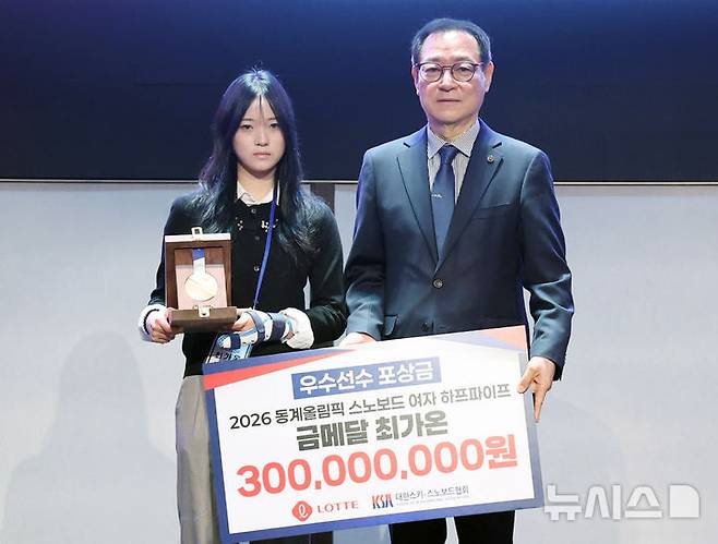 [서울=뉴시스] 배훈식 기자 = 2026 동계올림픽 스노보드 여자 하프파이프 금메달 리스트 최가온이 19일 오전 서울 송파구 시그니엘 서울에서 열린 2026 동계올림픽 대한민국 스키·스노보드 국가대표 선수단 격려 행사에서 우수선수 포상금을 받은 뒤 기념촬영을 하고 있다. 오른쪽은 최홍훈 대한스키스노보드협회장. 2026.03.19. dahora83@newsis.com