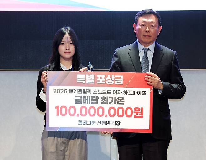 신동빈 롯데그룹 회장(오른쪽)이 19일 오전 서울 송파구 시그니엘 서울에서 열린 2026 밀라노·코르티나담페초 동계올림픽 대한민국 스키·스노보드 국가대표 선수단 격려 행사에서 스노보드 여자 하프파이프 금메달리스트 최가온에게 특별 포상금을 전달한 뒤 기념촬영을 하고 있다. 연합뉴스