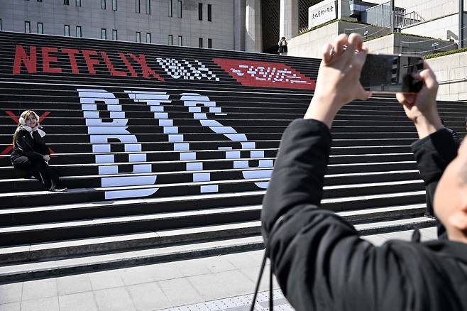 방탄소년단(BTS) 컴백 공연을 이틀 앞둔 19일 서울 종로구 세종문화회관 계단에 설치된 BTS 컴백 공연 관련 설치물과 함께 팬들이 추억을 남기고 있다. 조태형 기자 2026.03.19