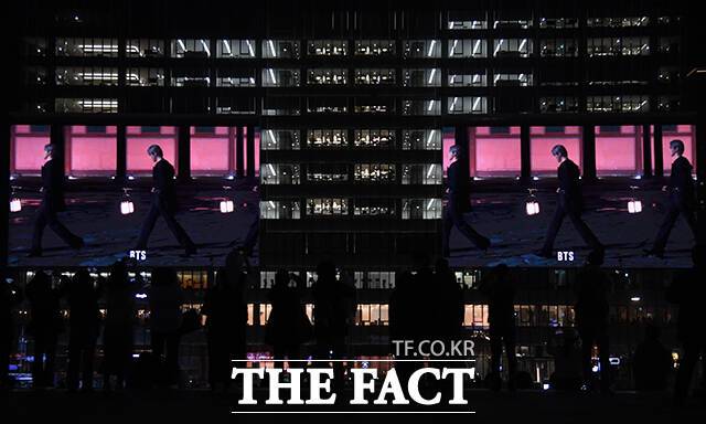 그룹 방탄소년단(BTS) 컴백 공연을 하루 앞둔 20일 오후 시민들이 서울 종로구 광화문광장 일대 건물 전광판에 상영되는 'BTS 경복궁 스페셜 필름'을 바라보고 있다. /박상민 기자