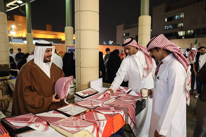 이슬람교 단식 기간 라마단 종료(이드 알피트르)를 약 일주일 앞둔 지난 12일 사우디아라비아 리야드의 한 전통 시장에서 시민들이 남성 전통 복장을 둘러보고 있다. 미군 거점을 겨냥한 이란의 중동 주변국에 대한 공습이 계속되면서 이들은 침체된 분위기 속에서 이슬람 최대 명절인 이드 알피트르를 맞게 됐다. /AFP 연합뉴스