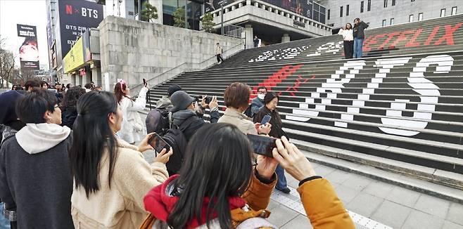 방탄소년단(BTS)의 컴백 공연을 이틀 앞둔 19일 서울 광화문광장에서 외국인 관광객이 BTS 관련 홍보물 앞에서 사진을 찍고 있다.  사진=임형택 기자