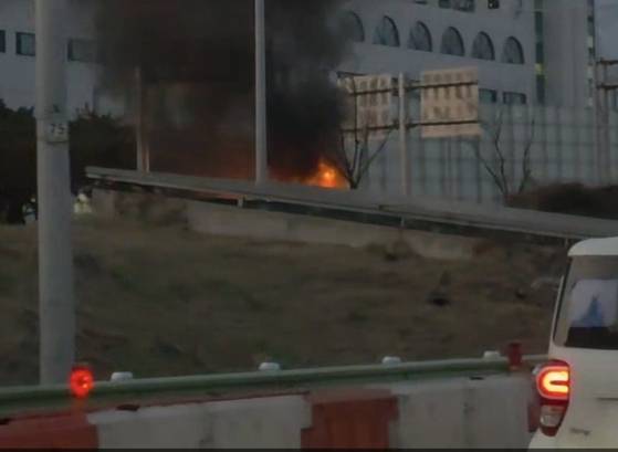 A passenger vehicle catches fire while driving down the Jamsil Railway Bridge on Olympic-daero in Songpa District, southern Seoul on March 20. [YONHAP]