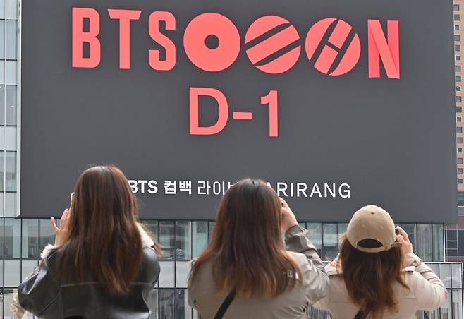 그룹 방탄소년단(BTS)의 컴백 공연을 하루 앞둔 20일 오전 서울 종로구 광화문광장에서 외국인 관광객들이 공연 광고를 스마트폰으로 촬영하고 있다. [임세준 기자]