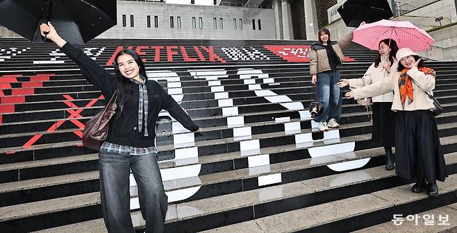 방탄소년단(BTS) 컴백 공연을 사흘 앞둔 18일 오후 서울 종로구 광화문광장을 찾은 팬들이 BTS 새 앨범 홍보 문구로 장식된 세종문화회관 계단에서 포즈를 취하고 있다. 공연을 보기 위해 광화문광장을 찾는 팬들이 늘면서 광화문이 영국 런던의 ‘애비로드’와 같은 상징적인 장소로 거듭날지 주목받고 있다. 양회성 기자 yohan@donga.com