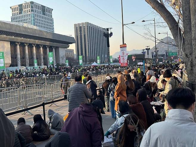 방탄소년단(BTS) 공연을 앞두고 아미(방탄소년단 팬덤)들이 전광판을 통해 공연을 볼 수 있는 교보빌딩 앞에 모여 앉아있다.