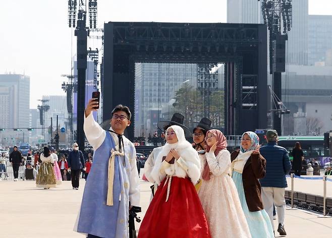 BTS 컴백 공연을 하루 앞둔 20일 한복을 입은 외국인 관광객들이 광화문광장 콘서트 무대를 배경으로 사진을 찍고 있다. /이솔 기자
