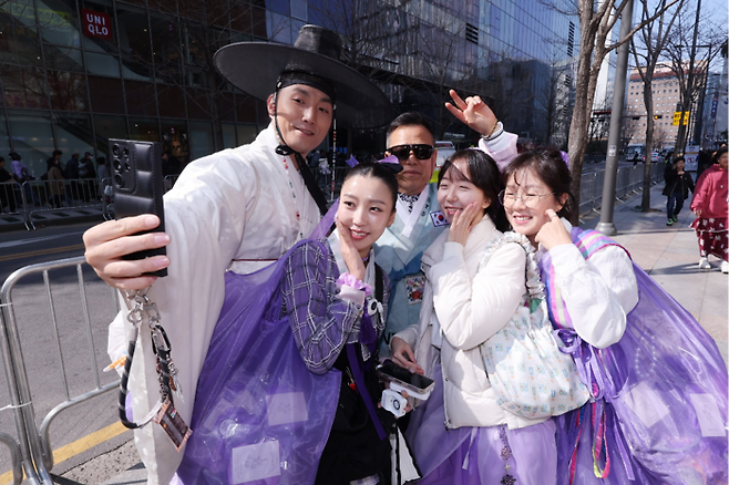 방탄소년단(BTS) 컴백 공연일인 21일 서울 광화문광장 인근에서 한복을 입은 아미들이 기념촬영을 하고 있다. [뉴스1]