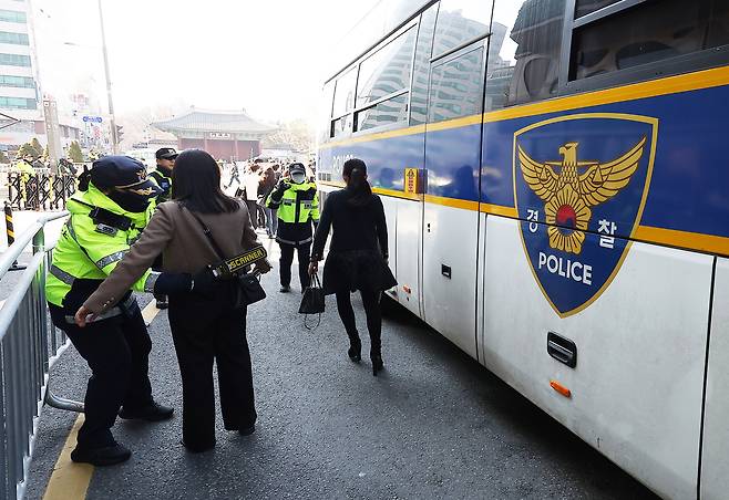 그룹 방탄소년단(BTS)이 정규 5집 ‘아리랑’(ARIRANG) 발매를 기념해 무료 공연 ‘BTS 컴백 라이브: 아리랑’(BTS THE COMEBACK LIVE｜ARIRANG)을 여는 21일 서울 광화문 광장 인근 결혼식장을 방문한 하객들이 버스에서 내려 검문검색을 받고 있다. [연합]