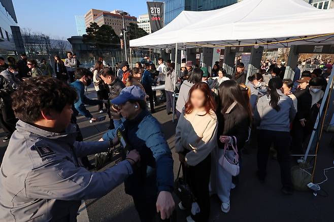 방탄소년단(BTS) 컴백 공연 당일인 21일 서울 종로구 광화문광장에서 팬들이 검색대를 통과하고 있다. [뉴시스]