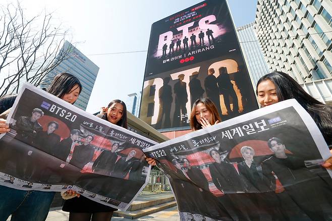 방탄소년단(BTS) 광화문 컴백 공연이 펼쳐지는 21일 서울 종로구 광화문 광장에서 미얀마인 아미(BTS 팬덤 명칭)가 세계일보 특별판 지면을 살펴보고 있다.