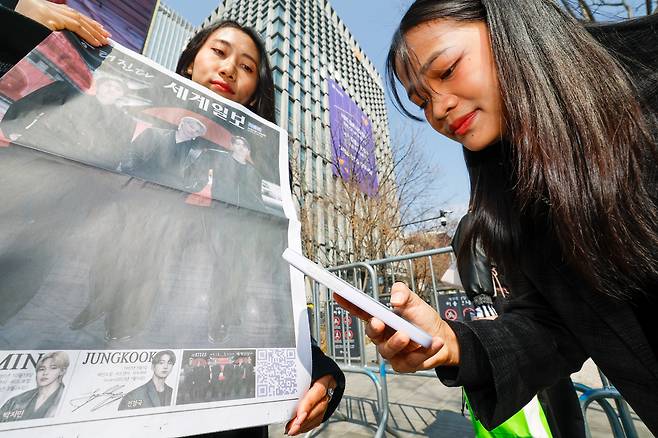 방탄소년단(BTS) 광화문 컴백 공연이 펼쳐지는 21일 서울 종로구 광화문 광장에서 미얀마인 아미(BTS 팬덤 명칭)가 세계일보 특별판 지면의 QR코드를 인증하고 있다.