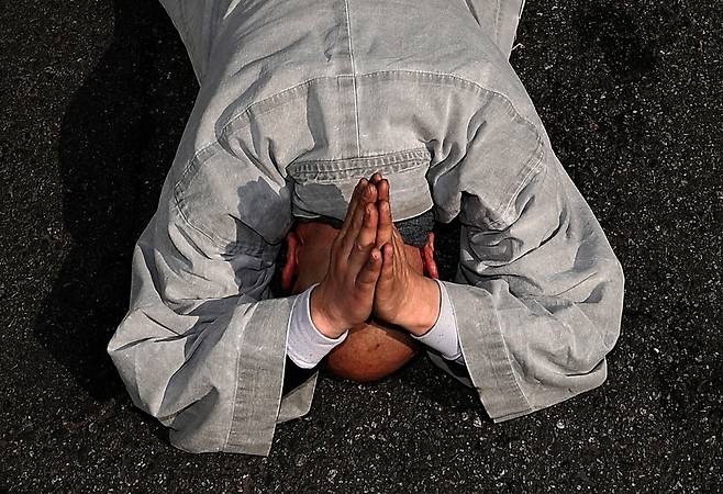 대한불교조계종 사회노동위원회 위원장 지몽스님이 아스팔트에 몸을 누여 중동 전쟁 중단과 군함 파견 거부를 호소하고 있다.