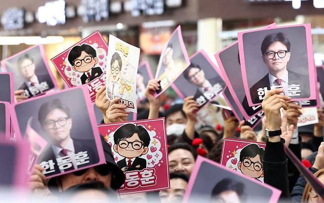 22일 오후 서울 동대문구 경동시장에서 한동훈 전 국민의힘 대표의 방문을 앞두고 지지자들이 피켓을 흔들고 있다. 뉴스1