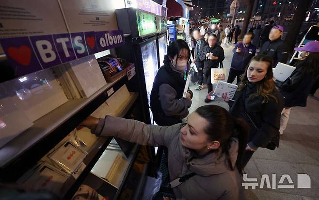 [서울=뉴시스] 조성우 기자 = 21일 서울 종로구 광화문광장에서 열린 'BTS 컴백 라이브: 아리랑(ARIRANG)' 공연이 끝난 뒤 한 해외팬이 인근 편의점에서 앨범을 구매하고 있다. 2026.03.21. xconfind@newsis.com