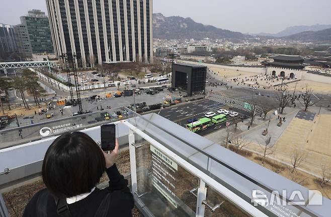 [서울=뉴시스] 김근수 기자 = 22일 오전 서울 종로구 광화문광장에서 전날 열린 방탄소년단의 'BTS 컴백 라이브 : 아리랑' 공연 무대 철거작업이 진행되는 가운데 외국인 관광객들이 사진을 찍고 있다. 2026.03.22. ks@newsis.com