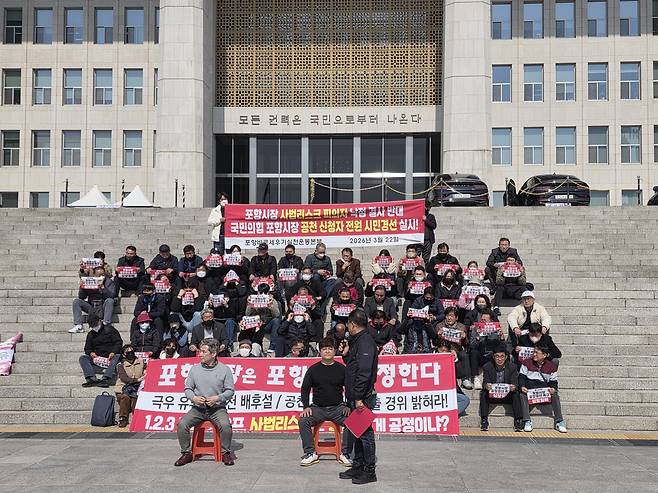 ‘포항바로세우기실천운동본부’ 소속 포항 시민들이 23일 오전 국회 본청 계단 앞에서 공천관리위원회를 향해 공천 기준 공개를 촉구 하고 있다.