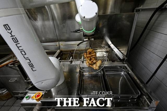 지난 6일 오후 서울 강동구 교촌치킨 고덕비즈밸리점에서 협동조리로봇이 치킨을 조리하고 있다. /서예원 기자