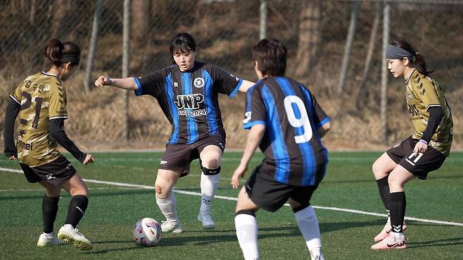 21일 인천 남동구 인천대공원 축구장에서 열린 ‘2026 우먼스 풋살 인천’ 대회에서 지니핑(파란색)과 카키 선수들이 볼을 다투고 있다. 우먼스풋살인천조직위 제공