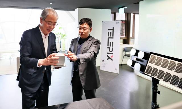 임종룡(왼쪽) 우리금융그룹 회장이 23일 주주총회에서 연임이 확정된 후 별도의 취임식 없이 서울 여의도 텔레픽스 본사에 방문해 조성익 대표에게 제품 설명을 듣고 있다. [우리금융그룹 제공]