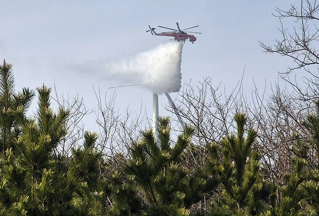 23일 오후 1시 11분께 경북 영덕군 영덕읍 창포리 풍력발전단지 내 한 풍력발전기에서 불이 난 가운데 현장에서 헬기가 진화작업을 하고 있다. 연합뉴스.